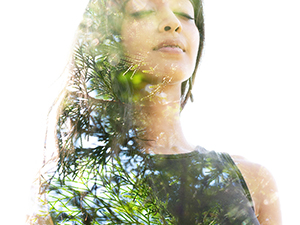 Double exposure close up of a young natural beauty with closed eyes combined with a healthy tree whose branches blend seamlessly into her healthy being