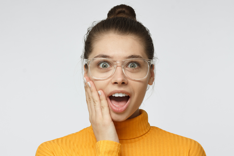 Woman in gold turtleneck sweater wearing clear-framed eyeglasses