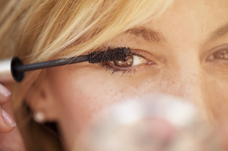 Closeup of woman's eye as she applies mascara