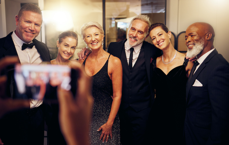 A group of people in semi-formal attire posing for a photo at a holiday party